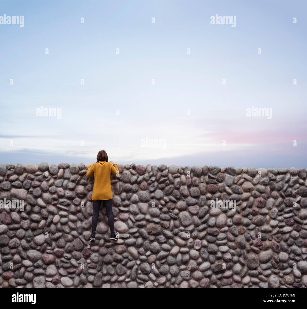 Frau, Steinmauer, festhalten über Spitze Stockfoto