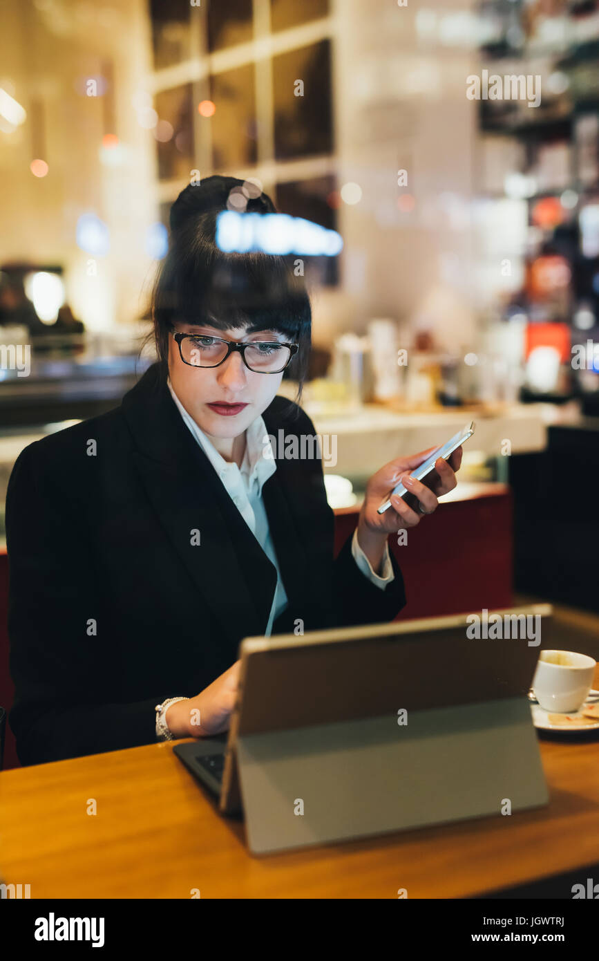 Geschäftsfrau mit Handy und digital-Tablette in café Stockfoto