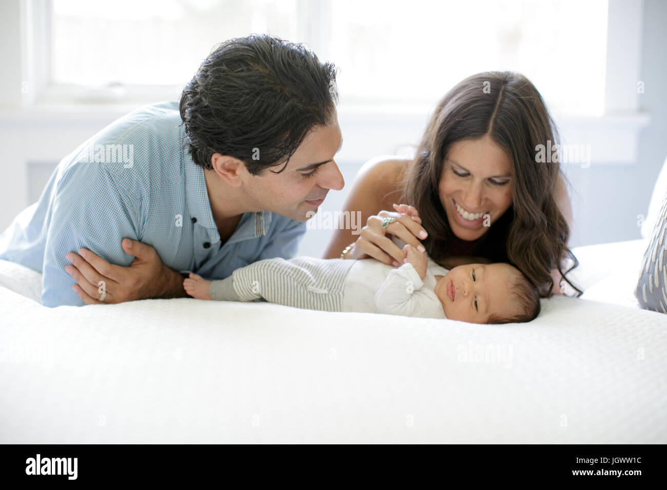 Mutter und Vater stützte sich auf Bett, Blick auf neugeborenes Baby boy Stockfoto