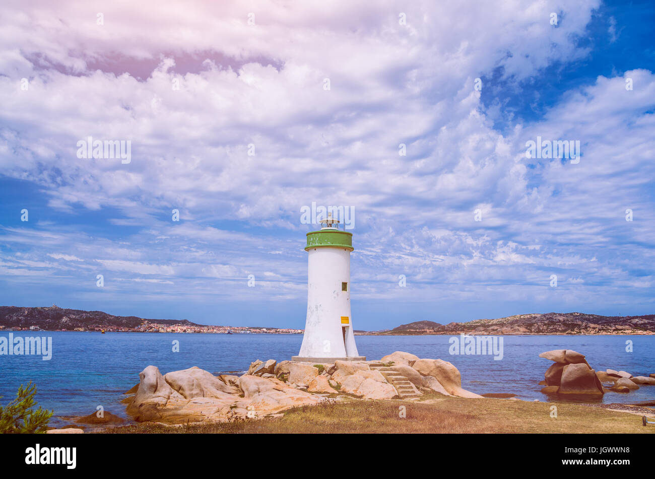 Weißer Leuchtturm und Wolkengebilde. Insel Sardinien, Italien Stockfoto