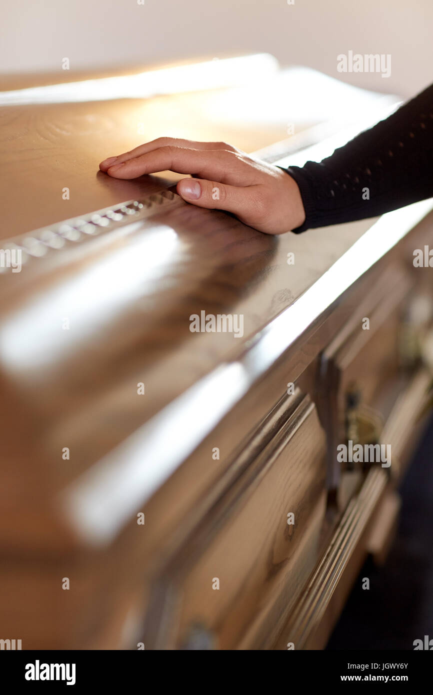 Frau hand aufs Sargdeckel bei Beerdigung in der Kirche Stockfotografie