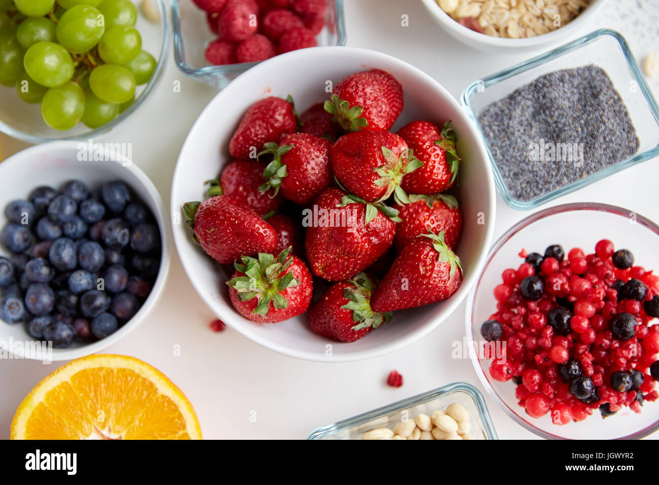 Früchte und Beeren in Schalen auf Tisch Stockfoto