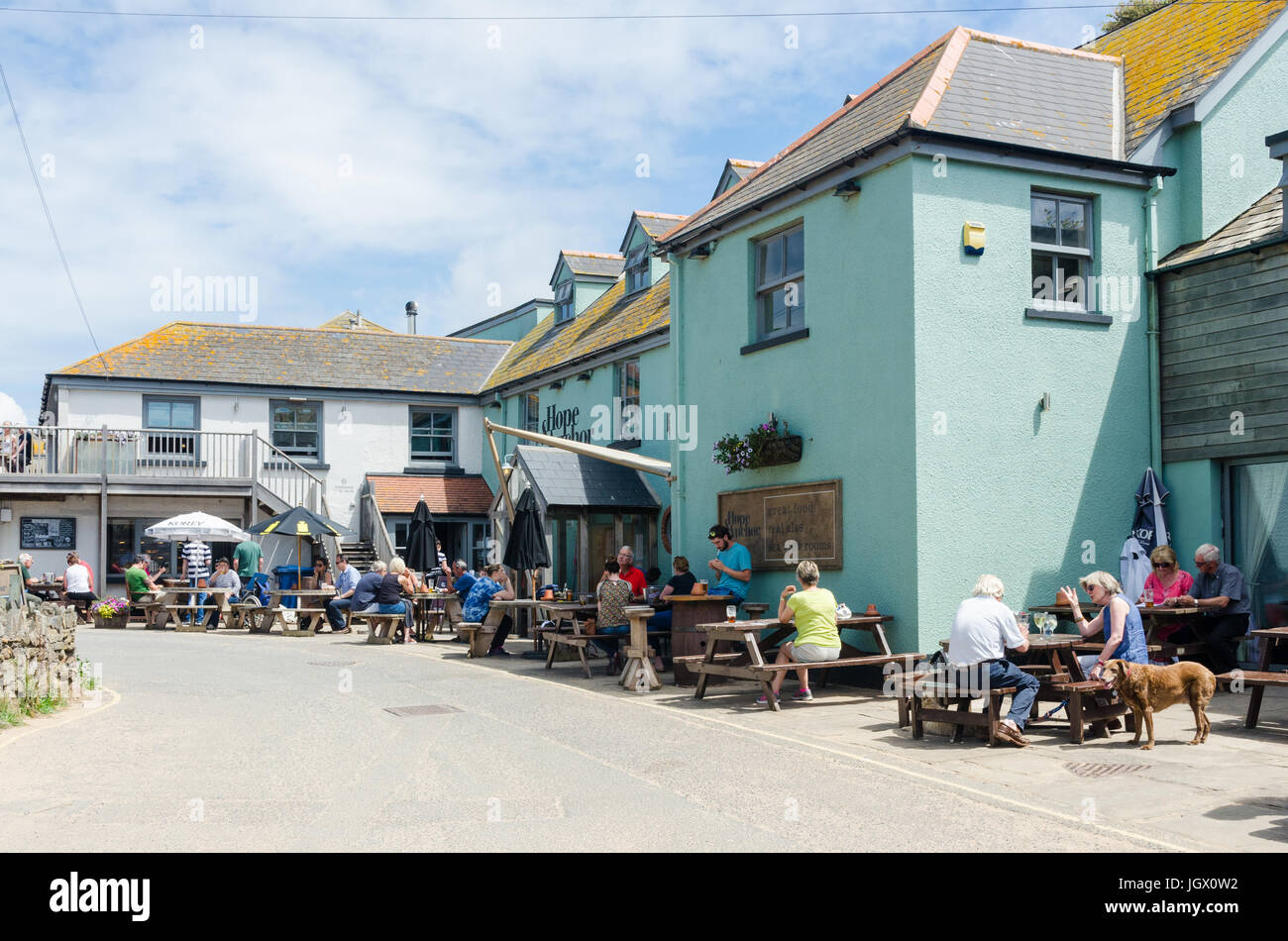 Menschen sitzen vor der Hoffnung und Anchor Pub in der hübschen South Hams Dorf von Hope Cove in Devon Stockfoto