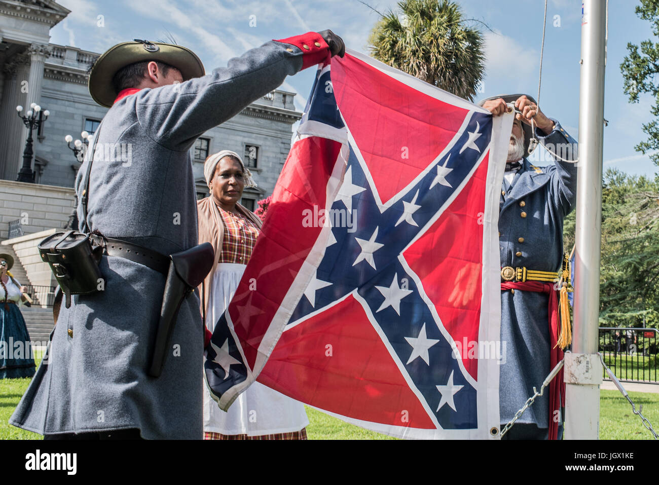 Kolumbien, Südcarolina, USA. 10. Juli 2017. Prominenten schwarz Konföderation Fan Arlene Barnum Stuart, Oklahoma und beobachtet, wie Konföderierten Reenactor Braxton Spivey von Charleston, South Carolina legt einen Konföderierten Flagge, eine tragbare Fahnenstange während Konföderierten die Flagge, die Veranstaltung von der South Carolina sezessionistische Partei aus Protest gegen das zweijährige bestehen der Konföderierten Battle Flag entfernen von der South Carolina State House im Jahr 2015 zu erhöhen. Bildnachweis: Crush Rush/Alamy Live-Nachrichten Stockfoto