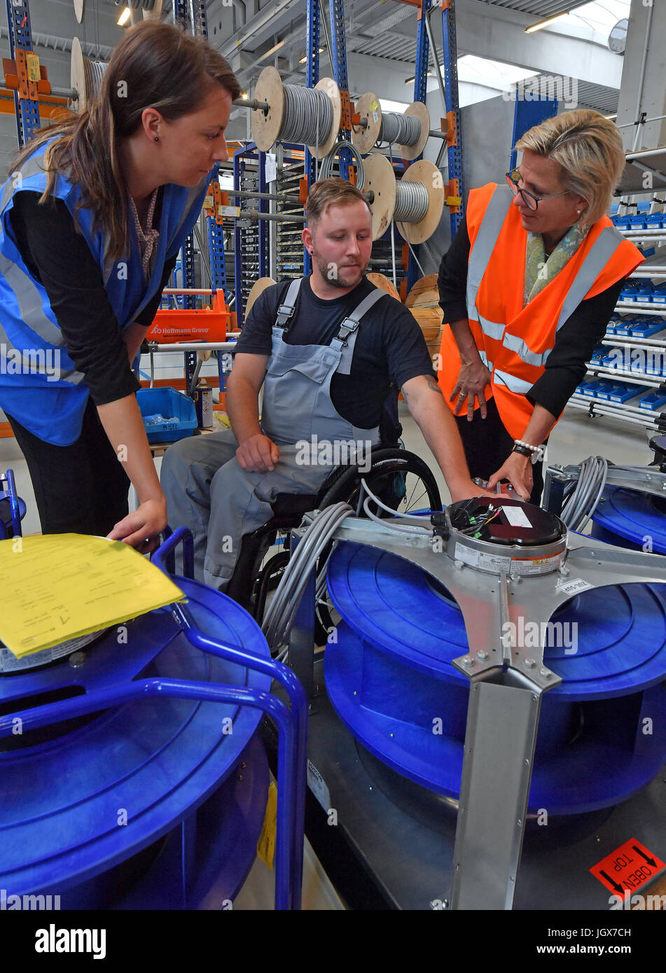 Sachsens soziale Ministerin Barbara Klepsch (CDU, r.) ist über einen barrierefreien Arbeitsbereich von Daniel Schlesinger Und Annelie Roemer aus der Personalabteilung bei DencoHappel Production GmbH in Wurzen, Deutschland, 11. Juli 2017 informiert. Schlesinger benutzt einen Rollstuhl seit einem Autounfall im Jahr 2012. Drei Viertel der ein Jahr nach seinem Unfall zurückgekehrt Schlesinger an den barrierefreien Arbeitsbereich bei der Firma arbeiten. Foto: Hendrik Schmidt/Dpa-Zentralbild/ZB Stockfoto