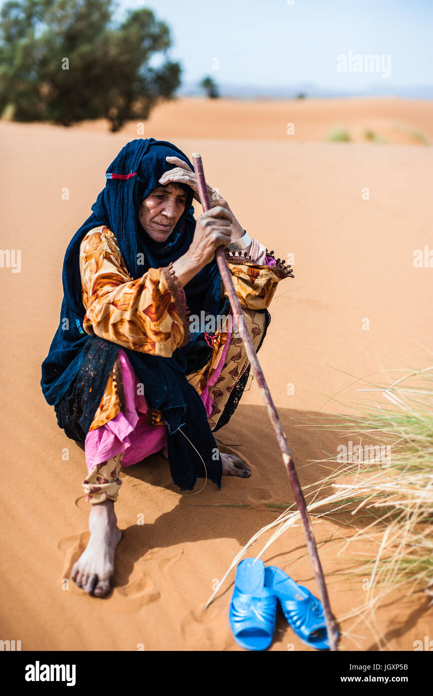 Porträt des alten Berber Frau sitzt auf einer Sanddüne in Merzouga, Marokko Stockfoto