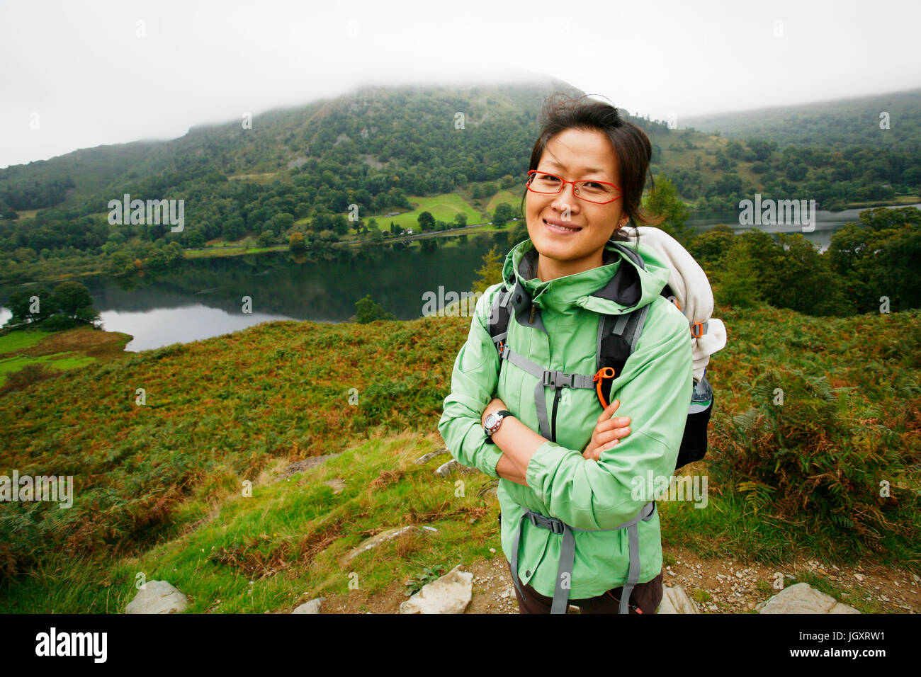 Lächelnd ostasiatischen Frau Wandern im Lake District, Cumbria, UK. Stockfoto