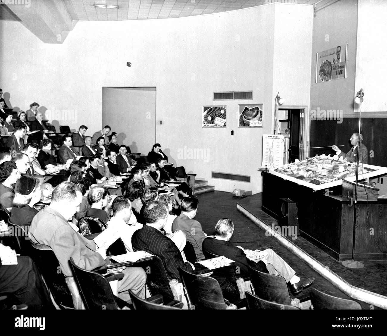 Ein Abendkurs Hochschule Johns-Hopkins-Universität befindet sich in einem Hörsaal Heften Notizen als Professor an der Vorderseite des Raumes einen Vortrag, 1930 steht. Stockfoto