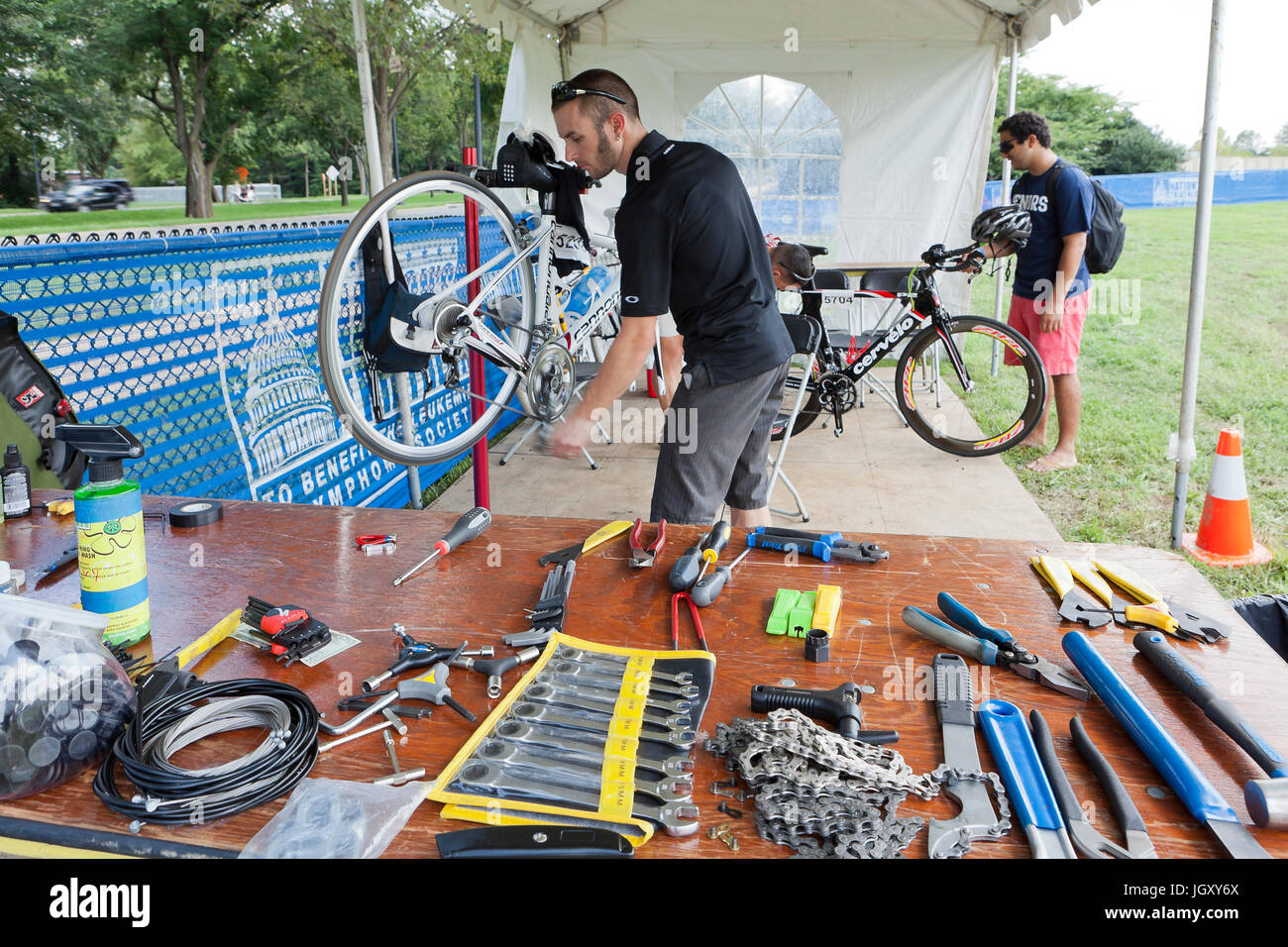 Fahrradmechaniker zur Festsetzung Rad mit dem Fahrrad auf dem Fahrrad montiert - USA Stockfoto