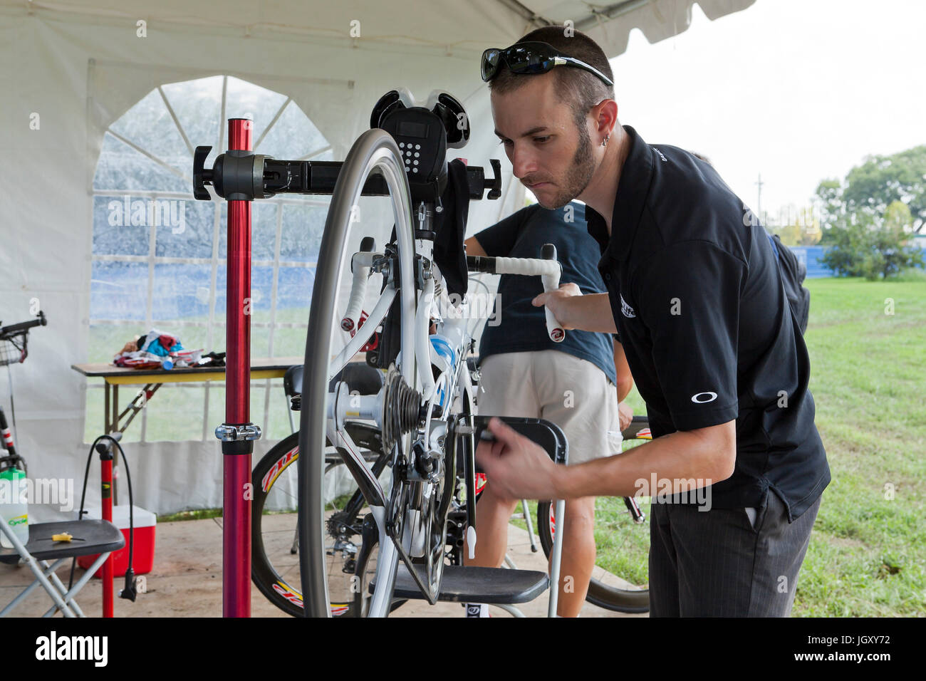 Fahrradmechaniker zur Festsetzung Rad mit dem Fahrrad auf dem Fahrrad montiert - USA Stockfoto