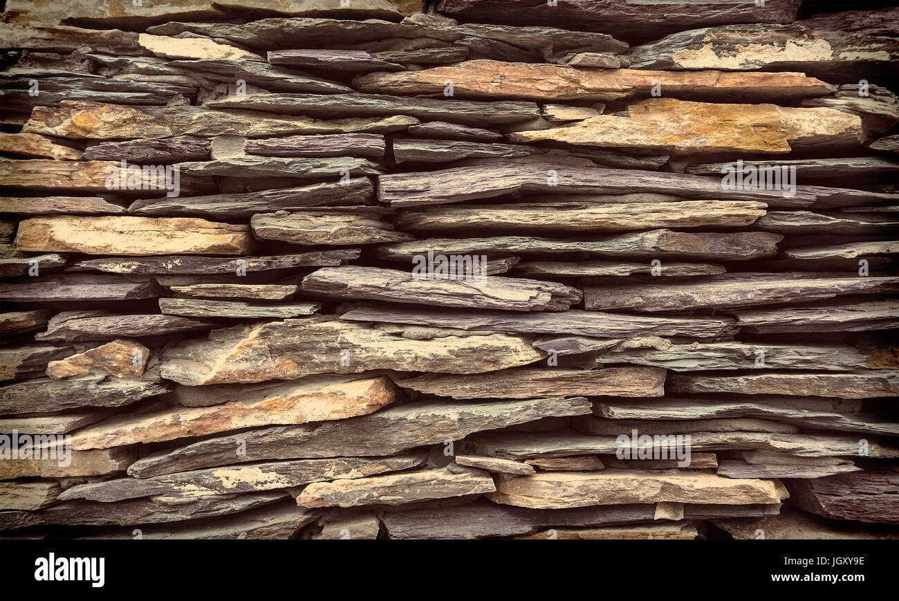 Hintergrund Mauer aus Stein. Eine Wand aus flachen Steinen, die in mehreren Reihen gelegt Stockfoto
