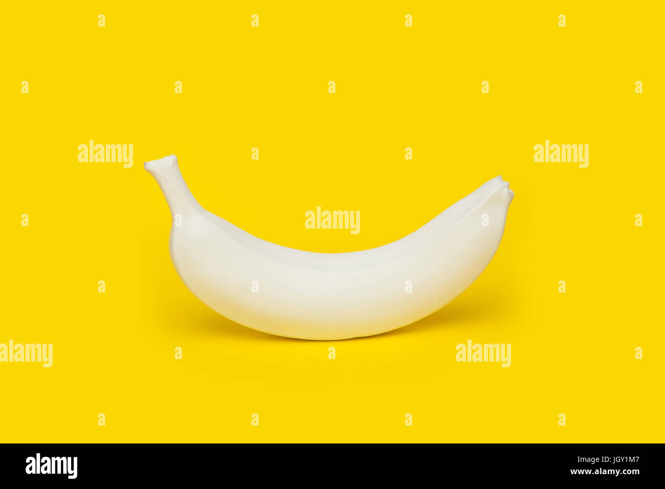 Banane auf gelbem Hintergrund weiß lackiert Stockfoto