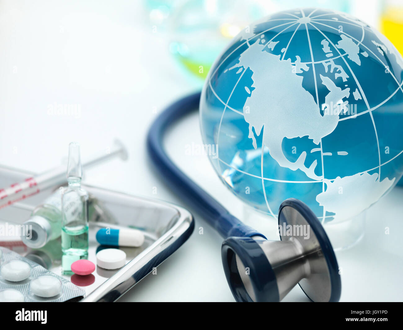 Globus zeigt Amerika mit akustischen Stethoskop und OP-Tray mit Medikamenten Stockfoto