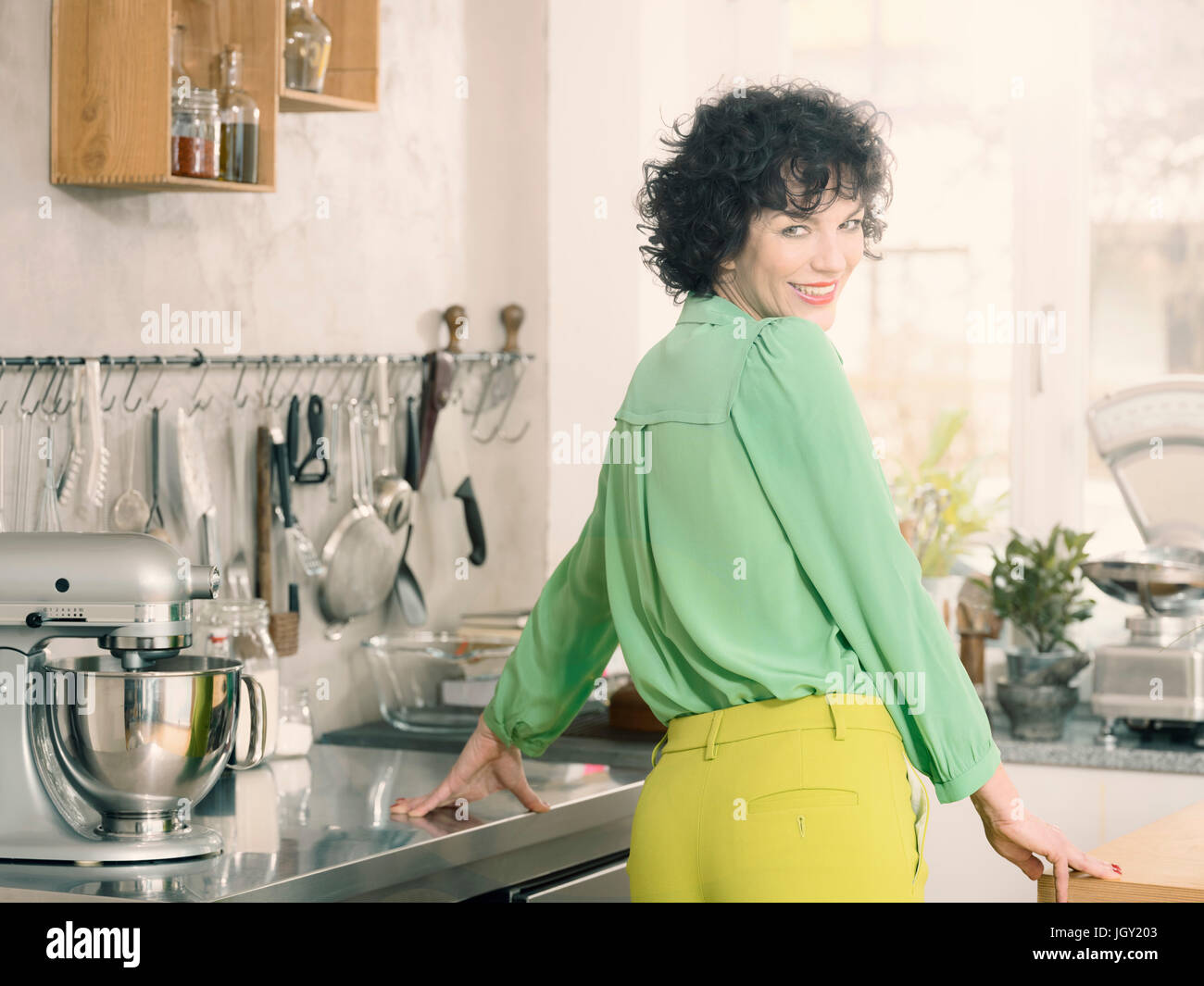 Porträt der Frau in der Küche über die Schulter in die Kamera Lächeln Stockfoto