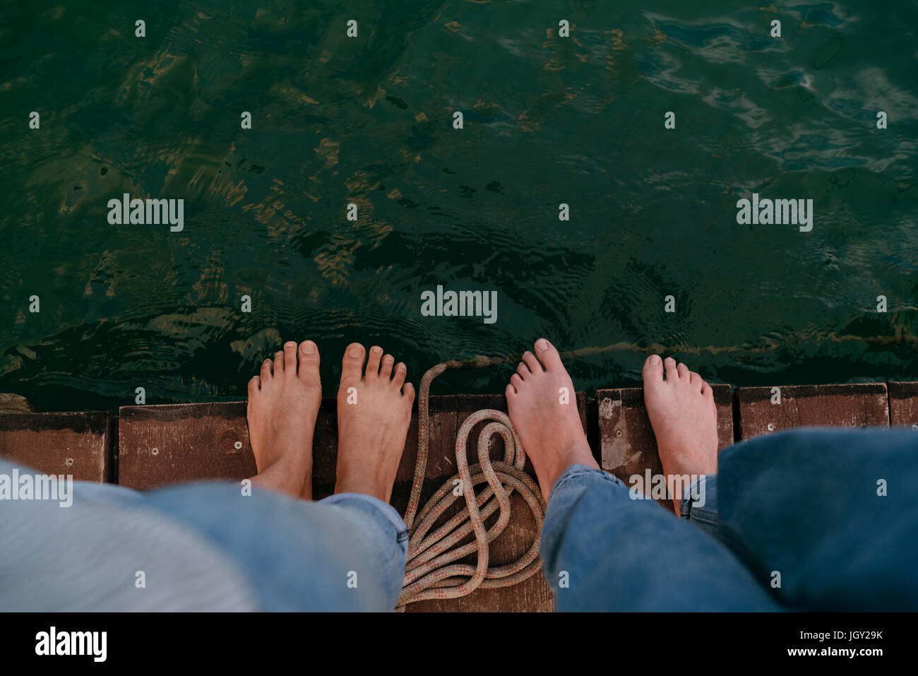 Zwei Frauen stehen auf Pier, barfuß, Draufsicht Stockfoto