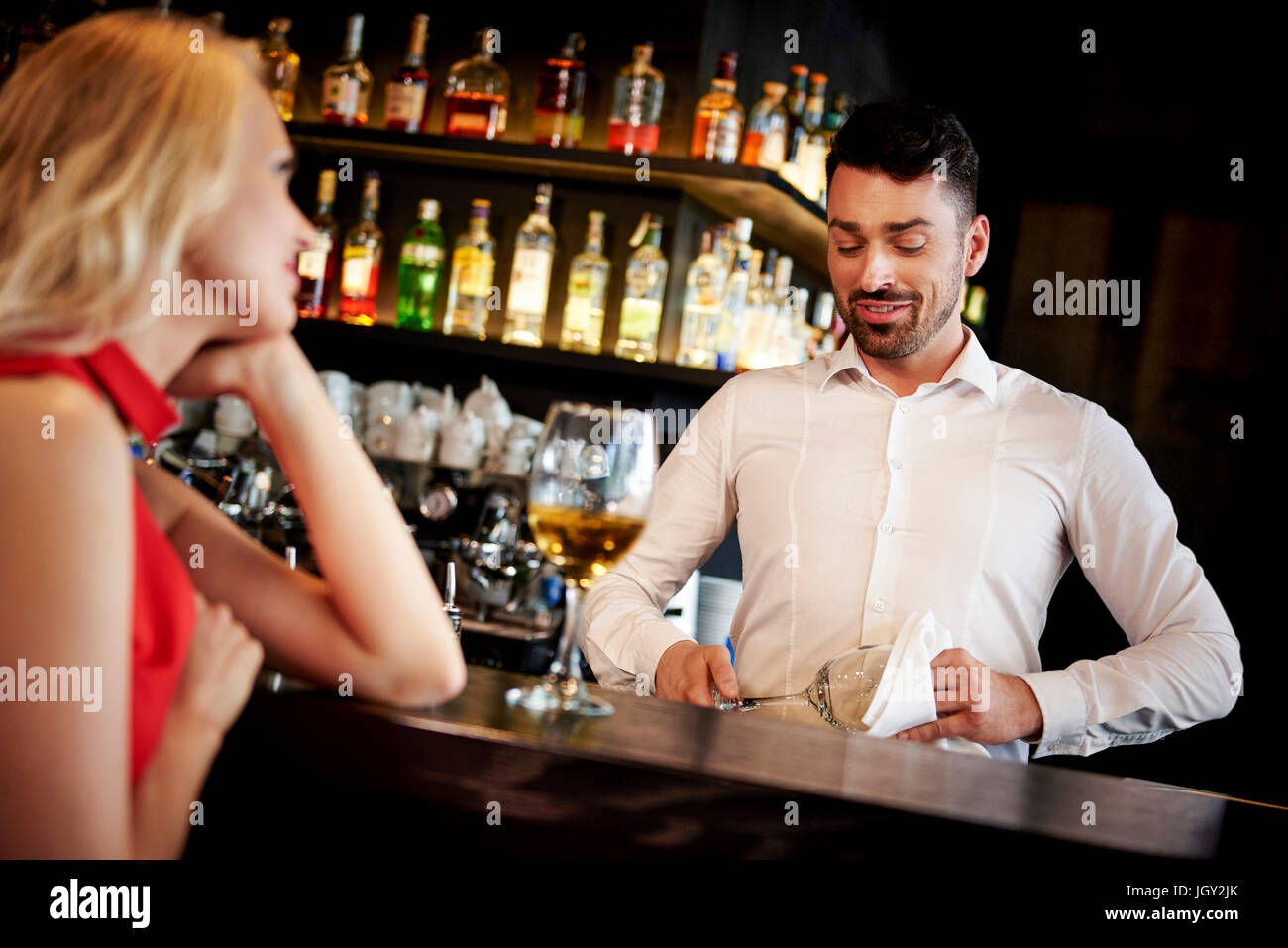 Barkeeper flirten mit jungen Frau an der bar sitzen Stockfoto