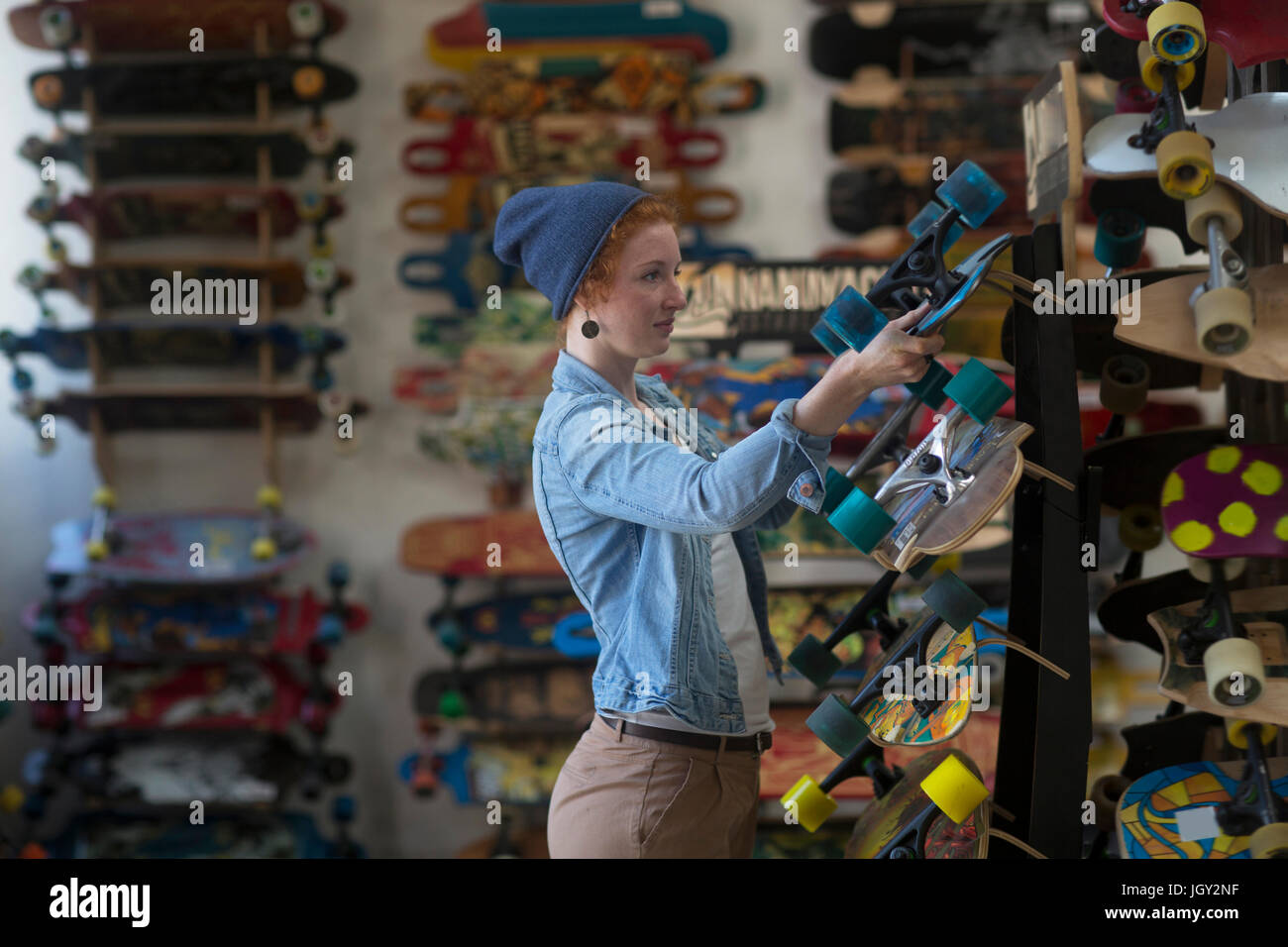 Frau arbeitet im Skateboard Shop, Skateboard-Display zu organisieren Stockfoto