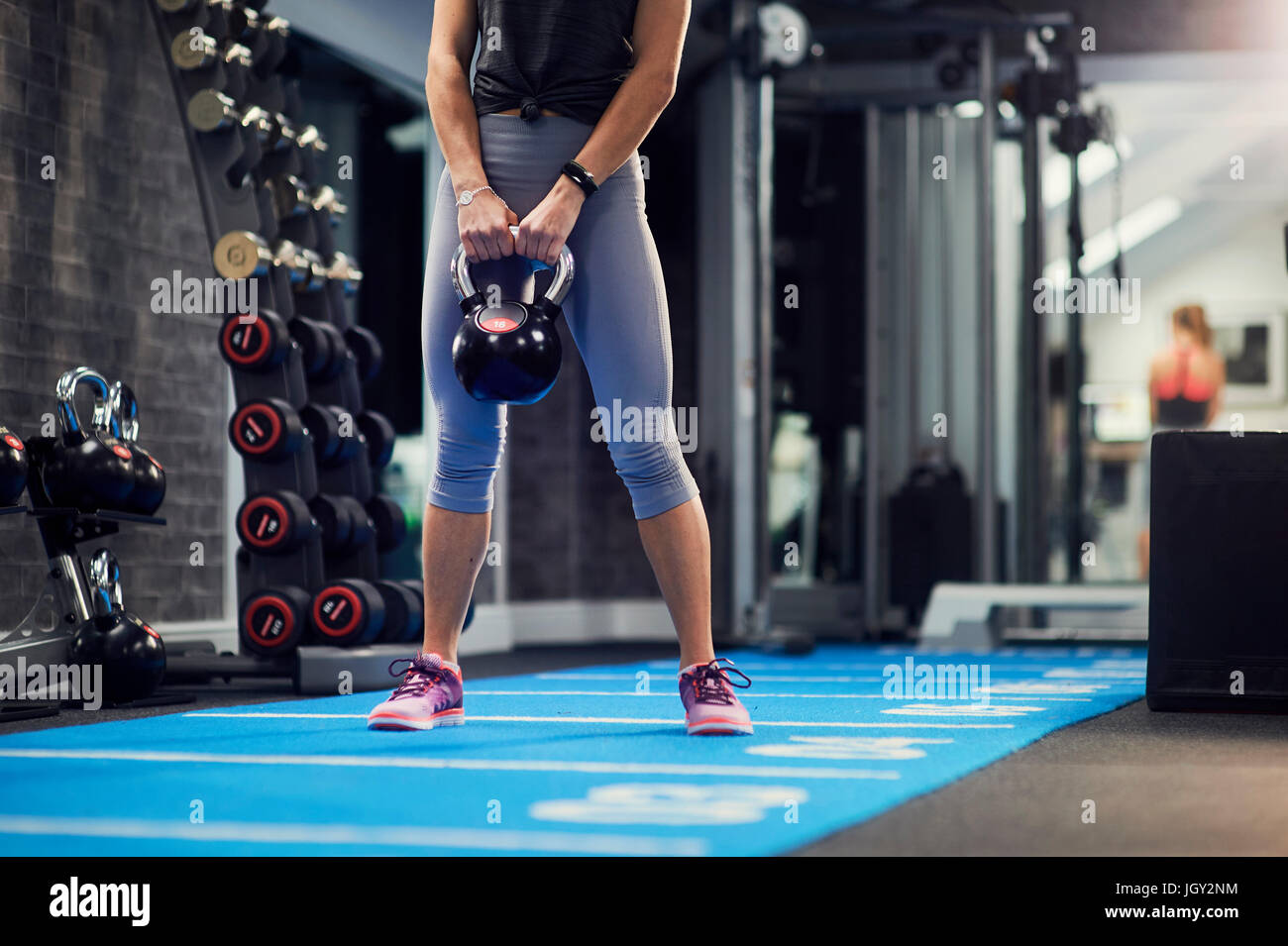 Taille abwärts Blick der jungen Frau mit Wasserkocher Glocke im Fitness-Studio Stockfoto