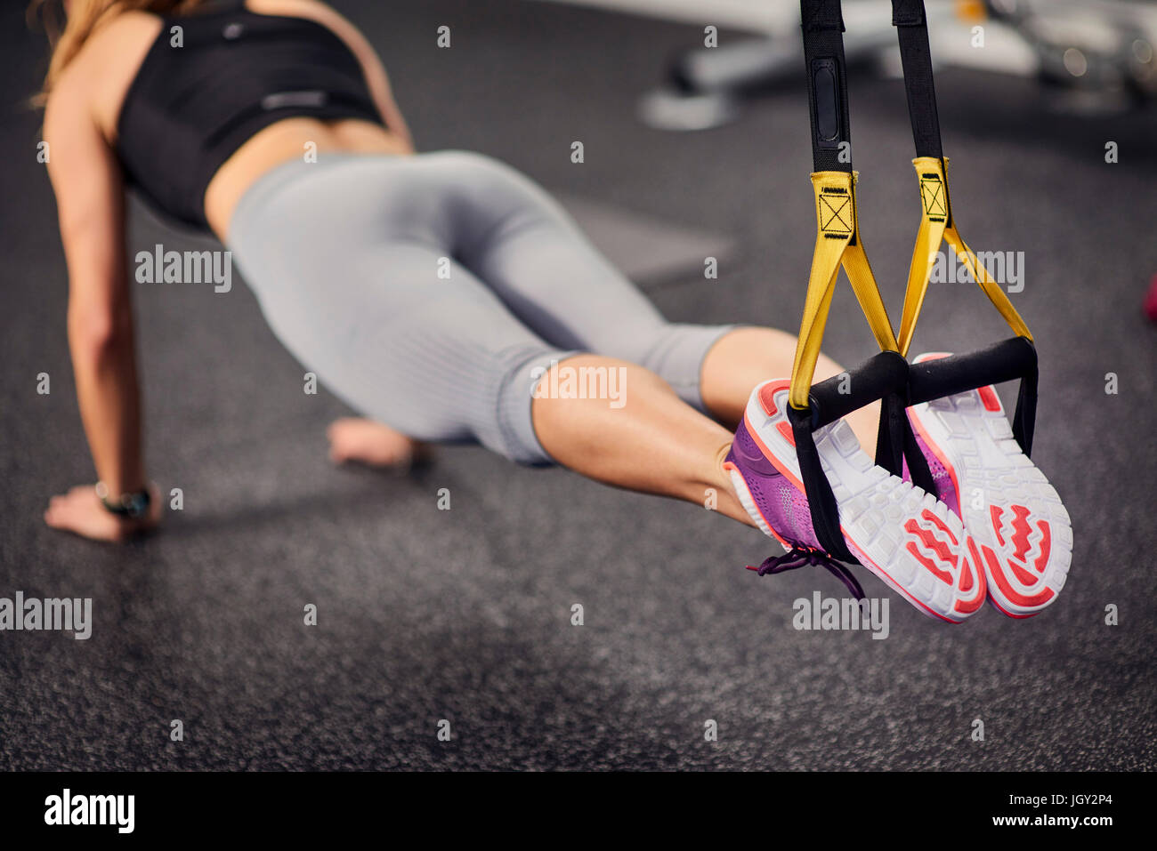 Hals abwärts Blick auf junge Frau tut Push ups mit Übung griffen im Fitness-Studio Stockfoto