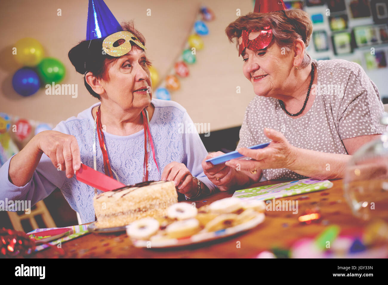 Ältere Frauen, die Geburtstagstorte auf party Stockfoto