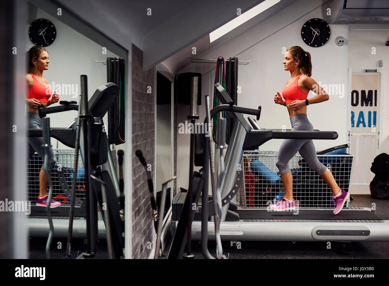 Junge Frau, training, laufen auf Fitness-Studio-Laufband Stockfoto