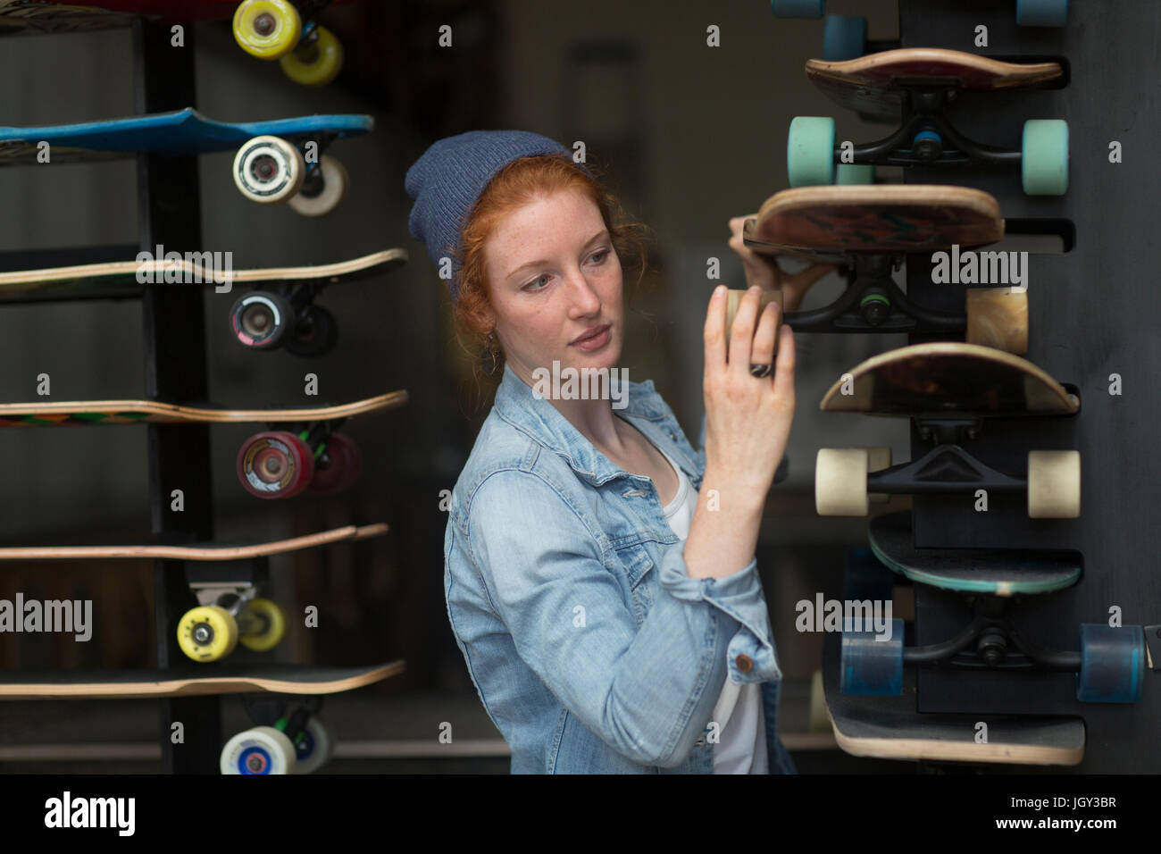 Frau arbeitet im Skateboard Shop, Skateboard-Display zu organisieren Stockfoto