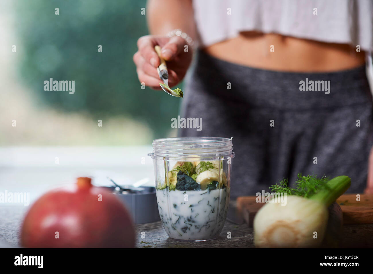 Junge Frau Vorbereitung smoothie Stockfoto