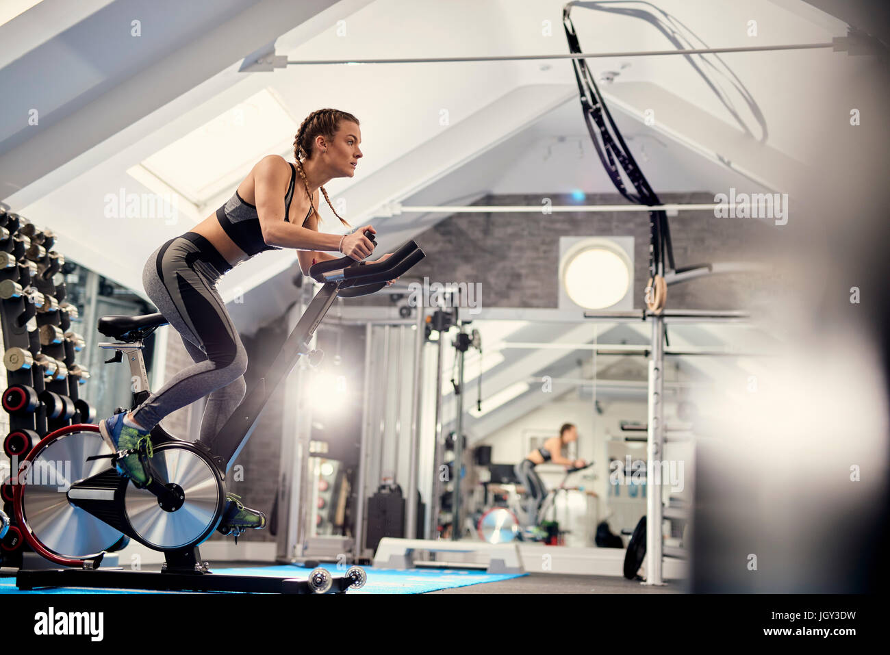 Junge Frau, training, Pedale Heimtrainer im Fitness-Studio Stockfoto