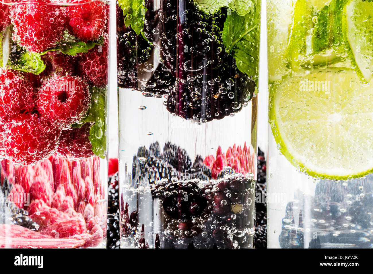 Drei Arten von Detox Wasser mit Brombeere, Erdbeere, lime mit Zutaten auf weißem Hintergrund aus Holz. Stockfoto