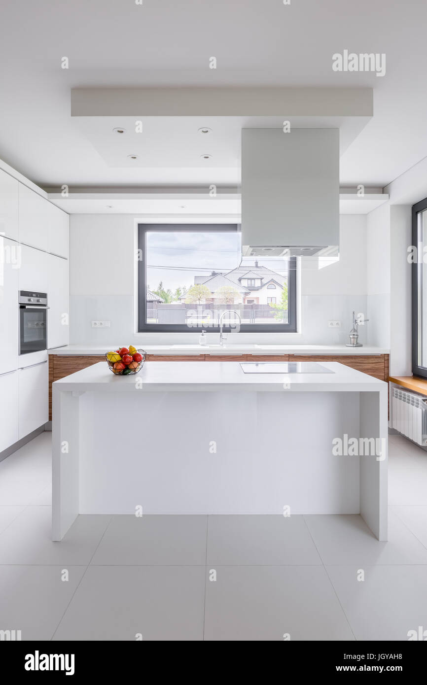 Stilvolle, weiße Küche mit Insel, Dunstabzugshaube und Fenster  Stockfotografie - Alamy