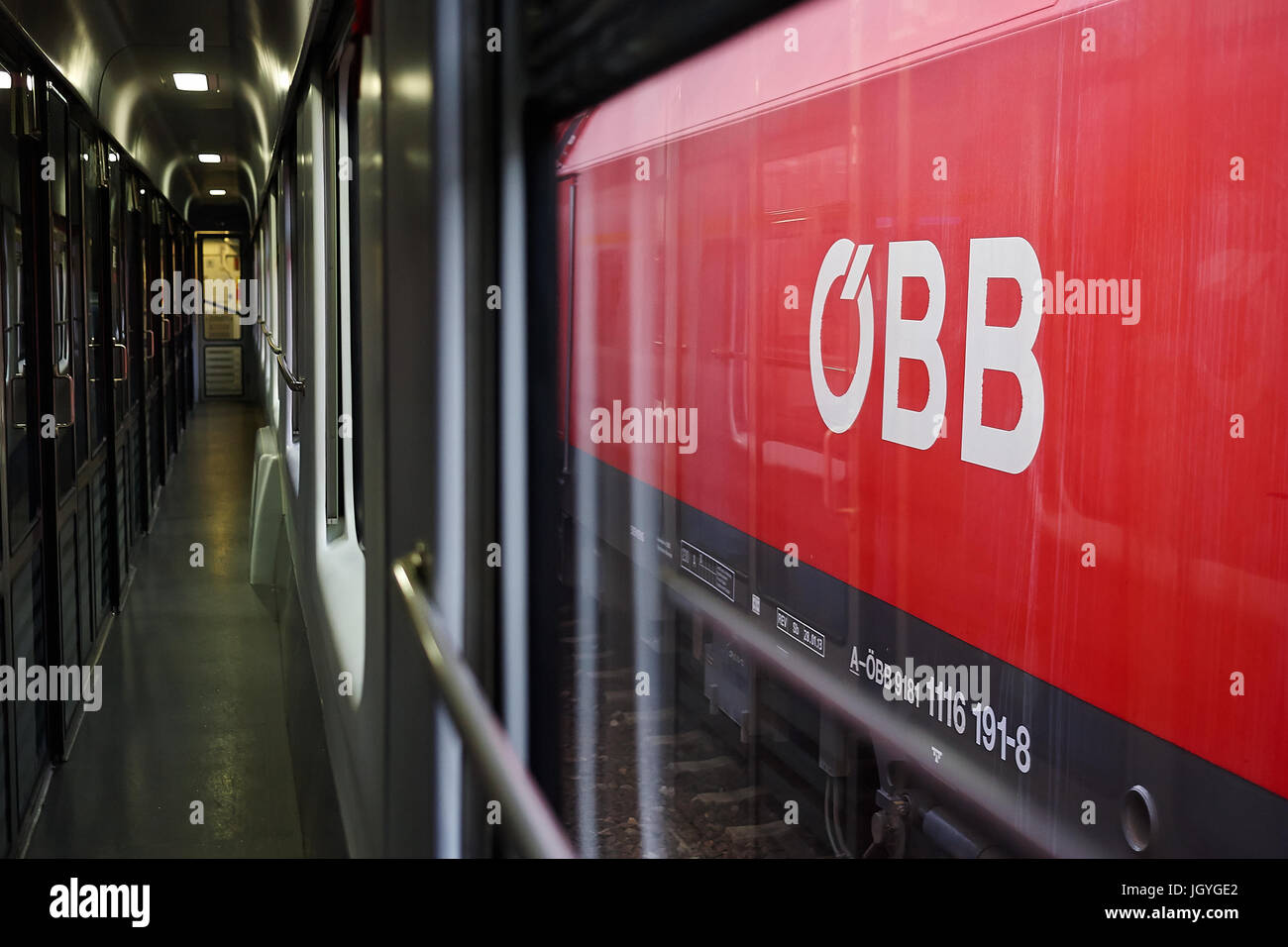 OBB, das Logo der österreichischen Bundesbahn, auf der Seite einen Zug von einem anderen Zug gesehen. Stockfoto