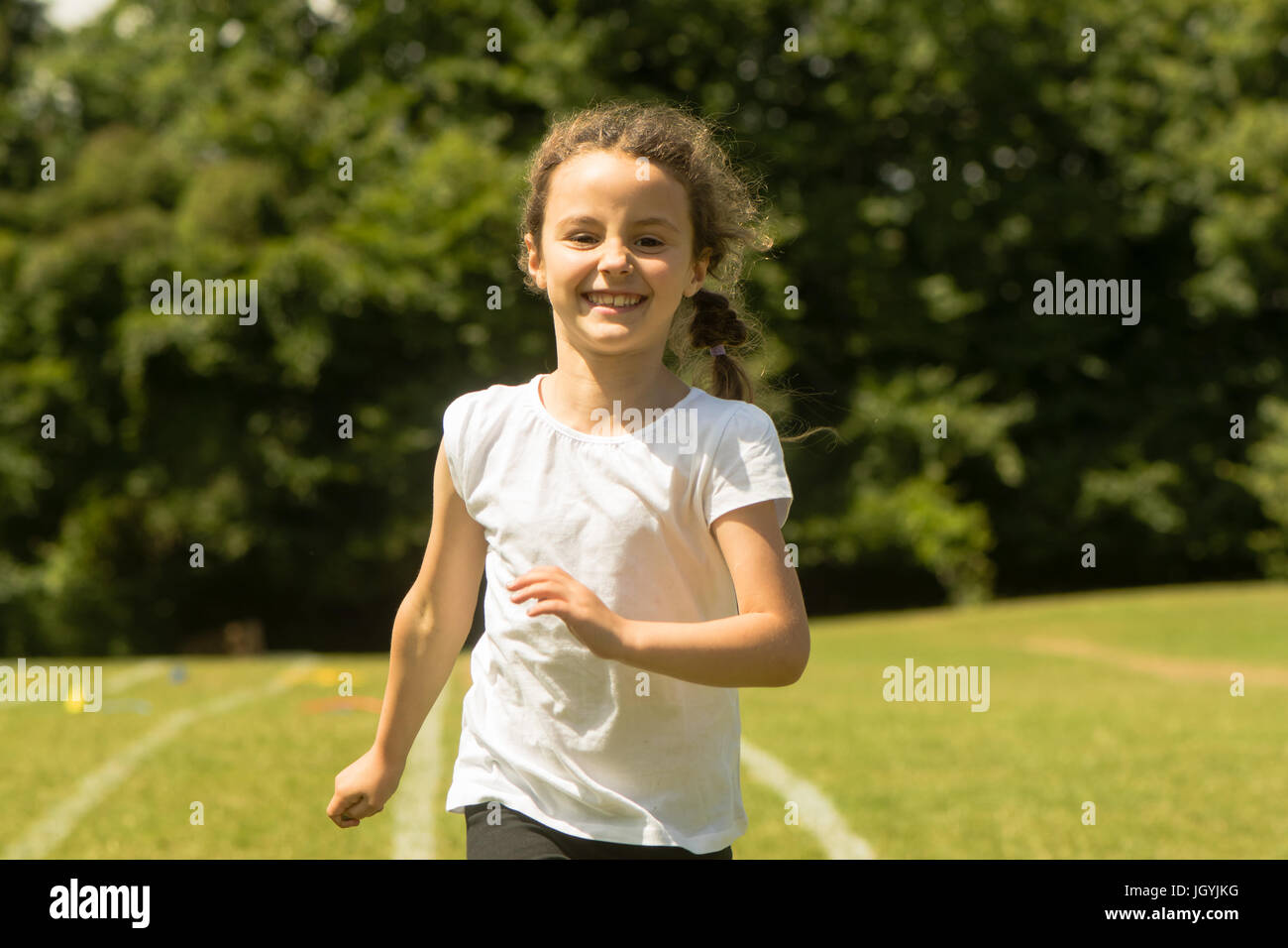Mädchen am Schulsporttag laufen. Junges Kind sprinten hart und glücklich während der traditionellen Schule Sommerevent Stockfoto