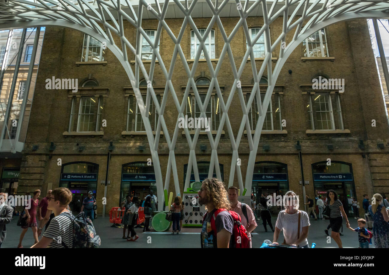 Die Menschen in der Halle am Bahnhof King's Cross, London, England, UK, vor der riesigen gewölbten Gitter Gitter Skulptur Dach von Arup Stockfoto