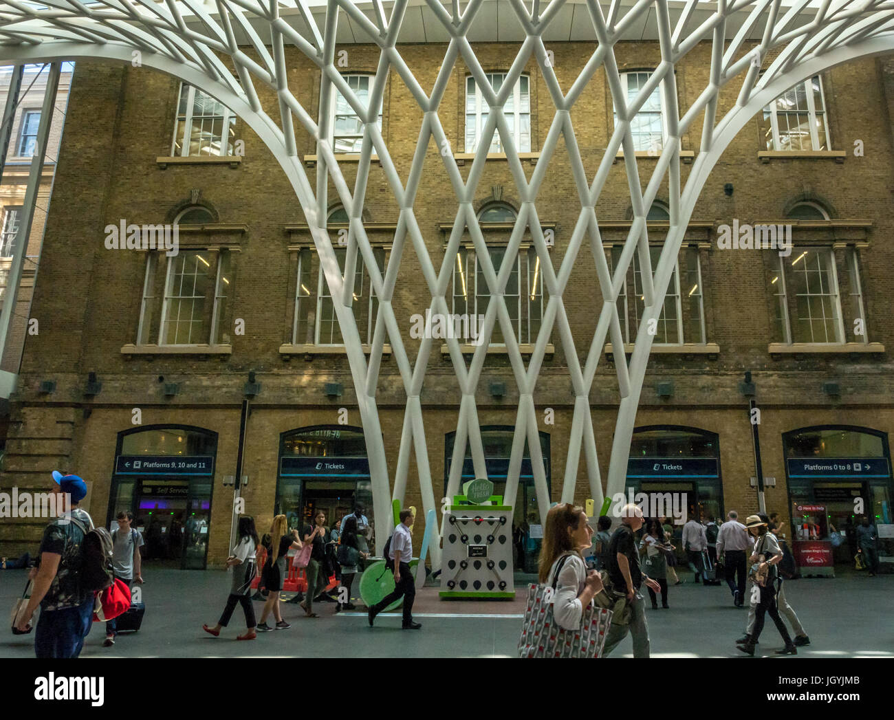 Die Menschen in der Halle am Bahnhof King's Cross, London, England, UK, vor der riesigen gewölbten Gitter Gitter Skulptur Dach von Arup Stockfoto