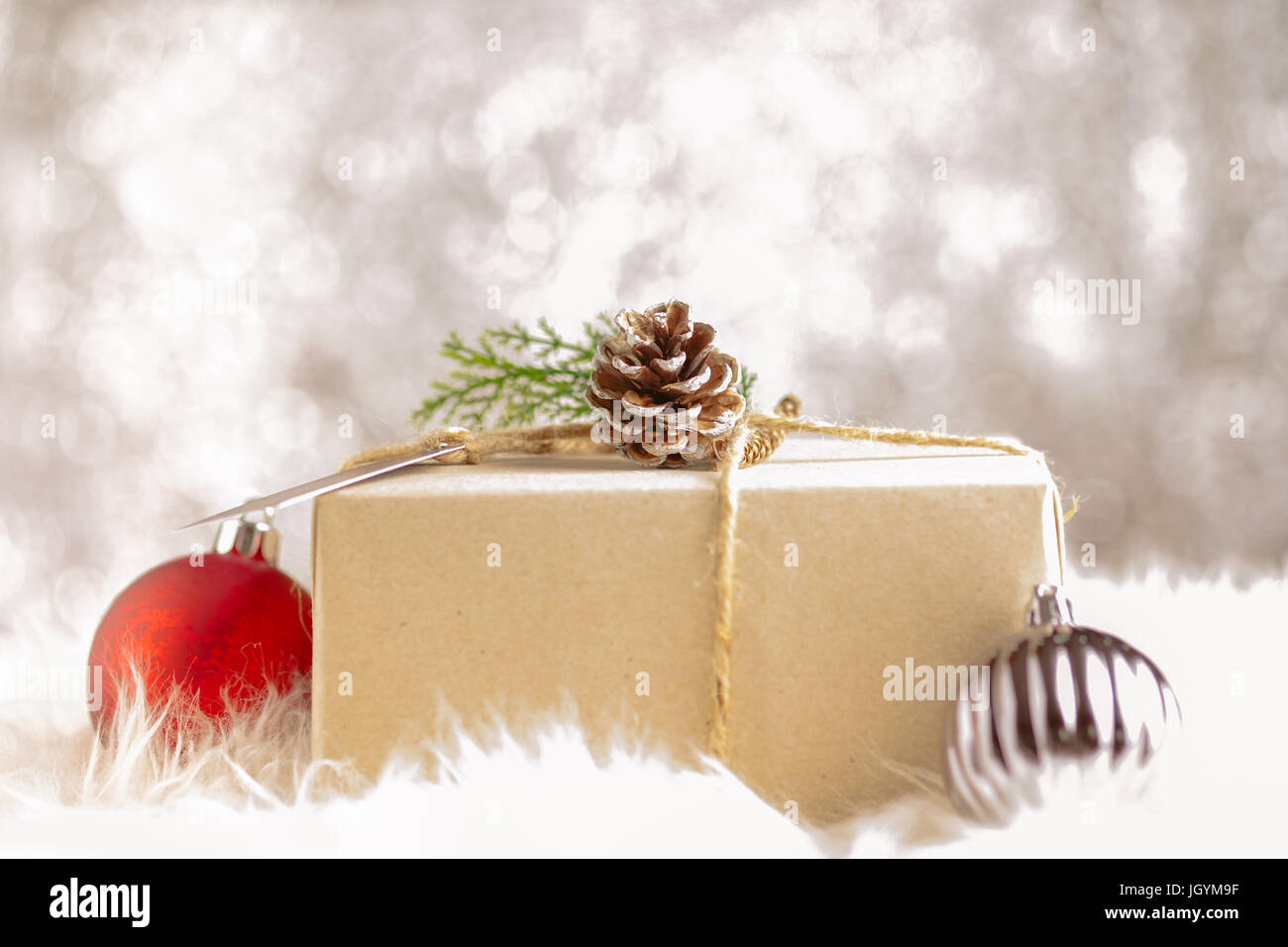 Braunen Papier Handwerk verzogen auf Geschenkbox dekorieren mit  Tannenzapfen und grünes Blatt Weihnachtskugel in funkelnden Bokeh  Backgrond, Geschenke für Urlaub se Stockfotografie - Alamy