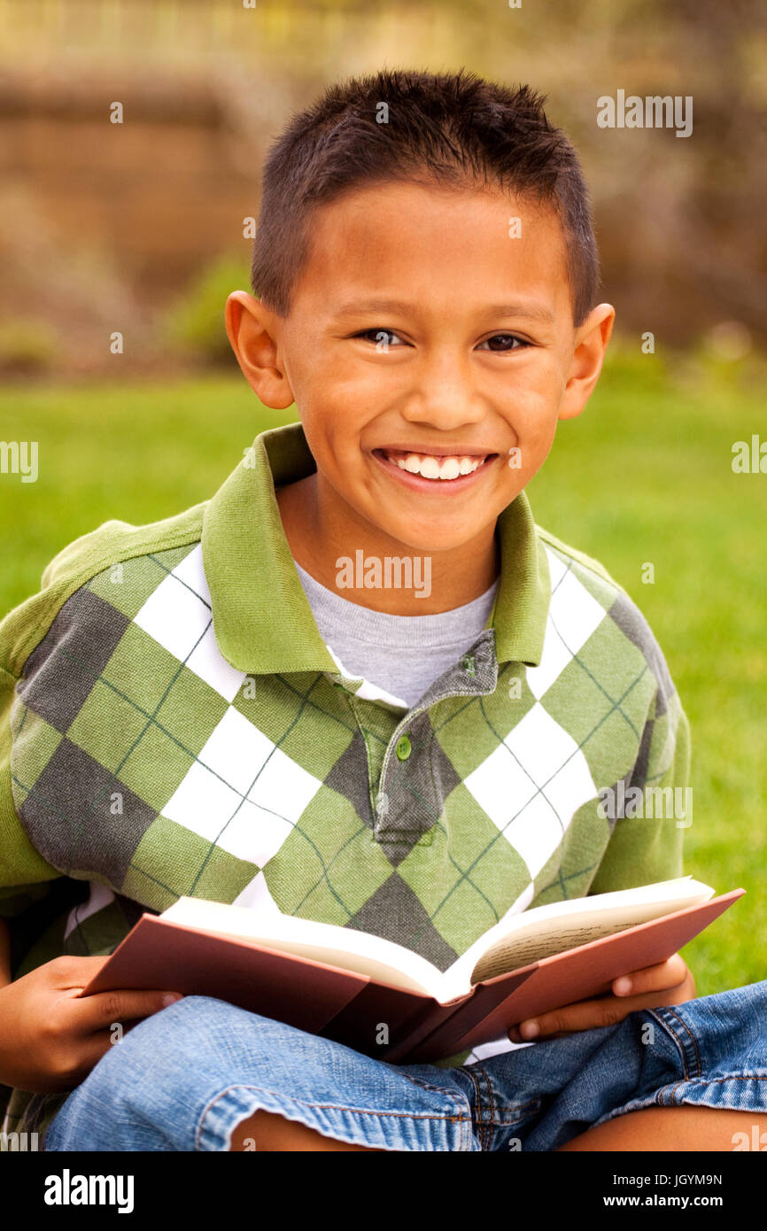 Glückliche junge Kinder Lächeln auf den Lippen und lesen vor. Stockfoto