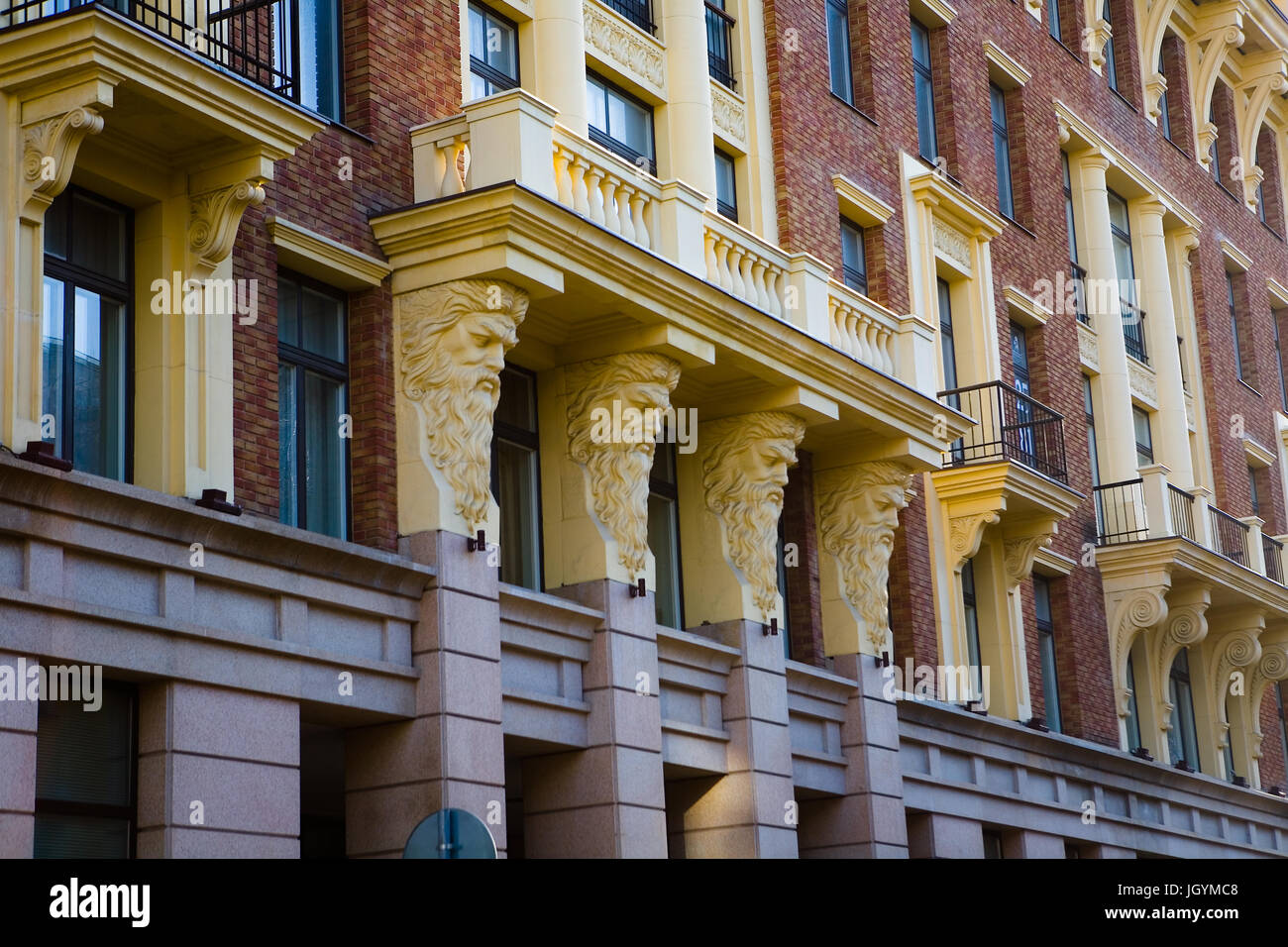 Architektonische Elemente des Gebäudes im Zentrum von Moskau. Der bärtige Köpfe der Männer halten den Balkon. Stockfoto