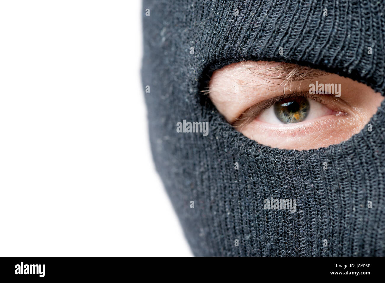 Nahaufnahme der Augen an das Verbrechen, dessen Gesicht durch eine schwarze Maske und den Raum auf der linken Seite abgedeckt ist Stockfoto