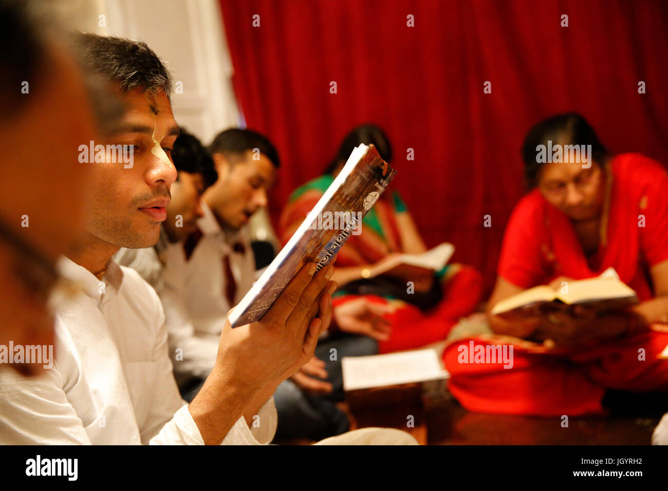 Gita Jayanti Feier in einem ISKCON-Tempel. Anhänger der Bhagavad Gita lesen. Sarcelles. Frankreich. Stockfoto