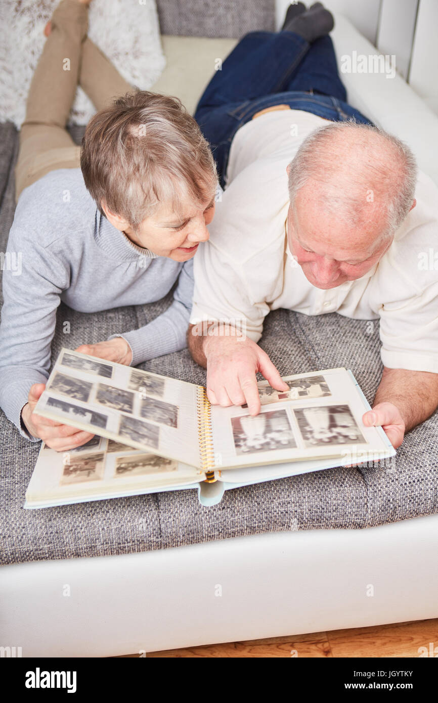 Senioren im Ruhestand halten Fotoalbum und betrachten es Stockfoto