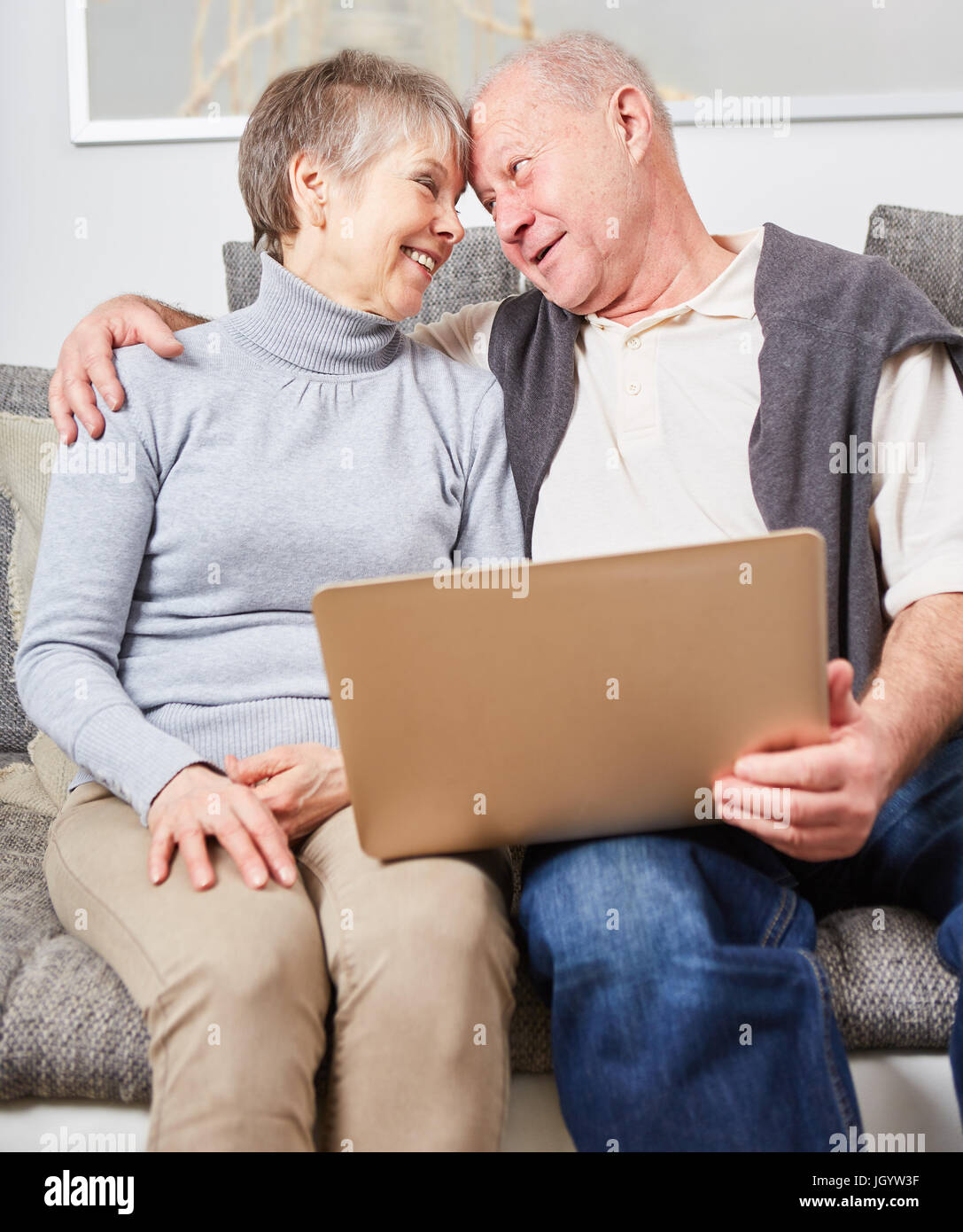 Senioren in der Liebe als ein paar hält einen laptop Stockfoto