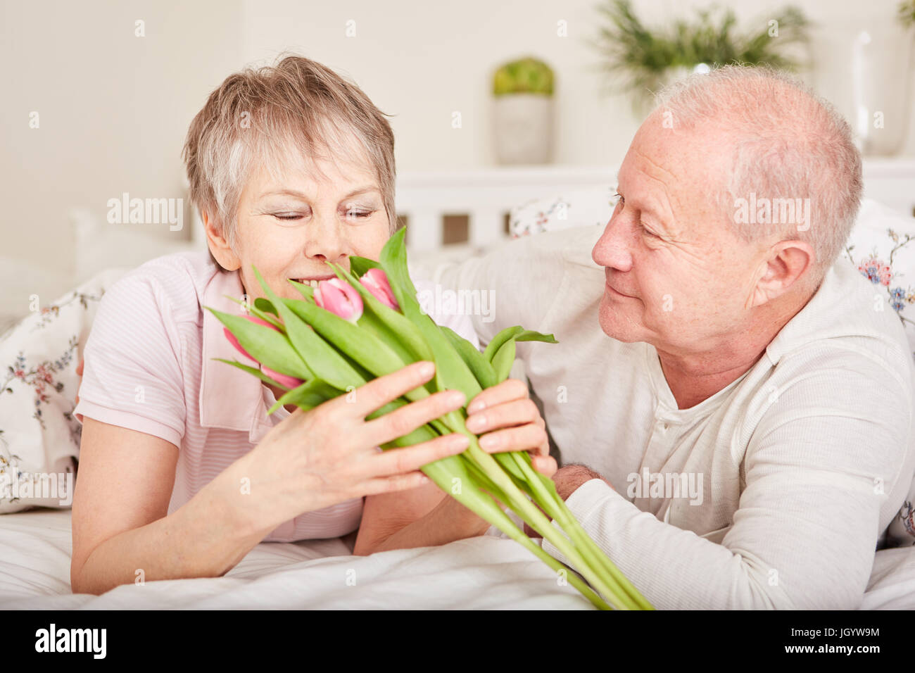 Senior woman spendet Blumen an Frau für Valentinstag Stockfoto