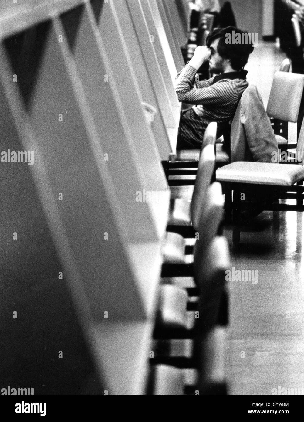Johns Hopkins University Student sitzt an einer Studie Station ruht seine Hände auf den Kopf, in der Universität Milton S Eisenhower Library in Baltimore, Maryland, 1965. Stockfoto