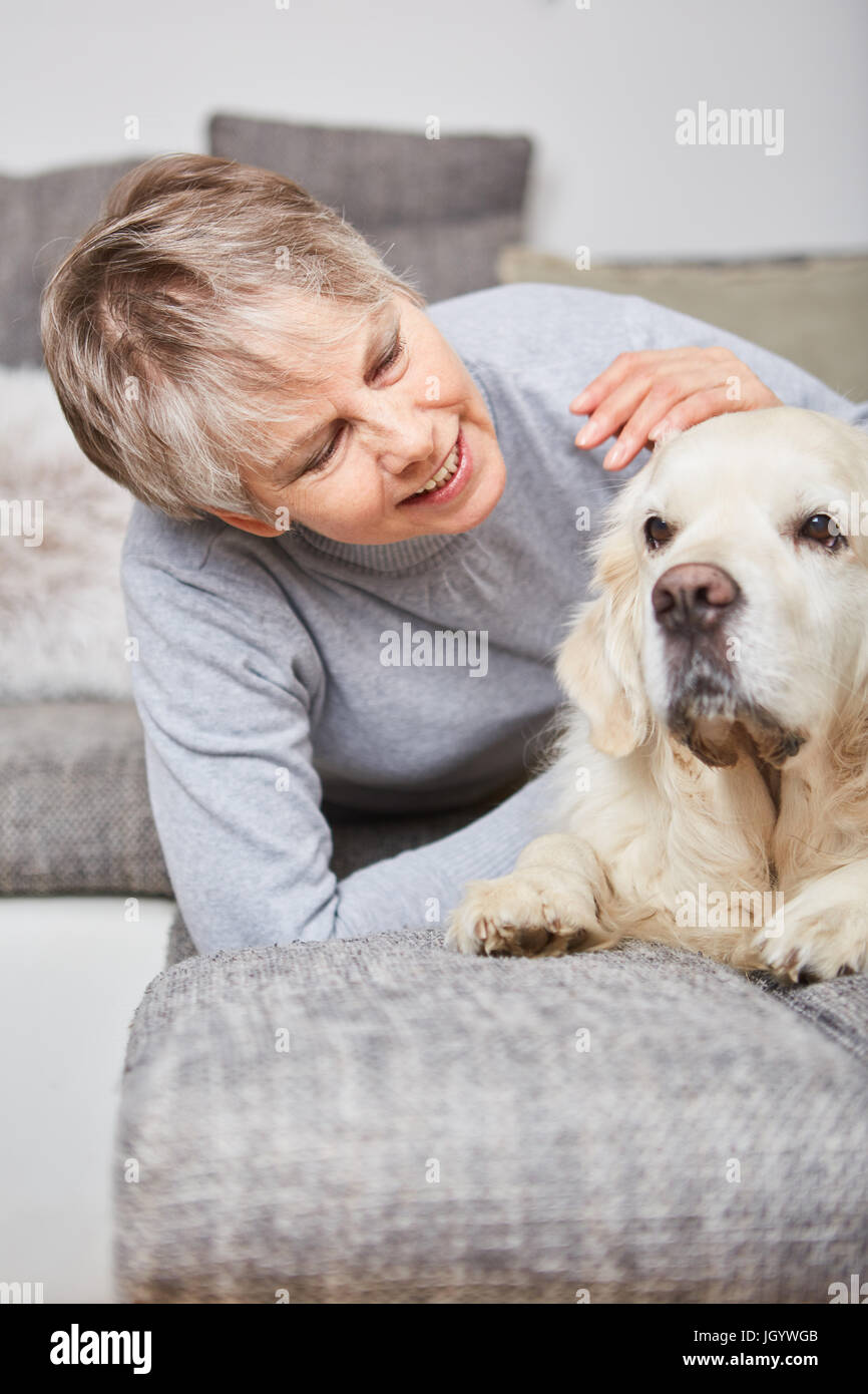 Ältere Frau mit Hund streichelt ihn Stockfoto