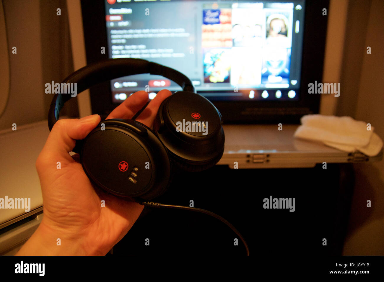 TORONTO, Kanada - 28. Januar 2017: Air Canada Business Class-Sitz mit der persönlichen Unterhaltungssystem riesige HD-Monitor mit aktive Noise cancelling Kopfhörer innerhalb einer Boeing 777-300ER von AC Air Canadas 777-300ER Businessclass auf diese Konfiguration besteht aus insgesamt 40 Plätze als eine umgekehrte Fischgräten Sitzplätze, verteilt auf zwei Kabinen. Stockfoto