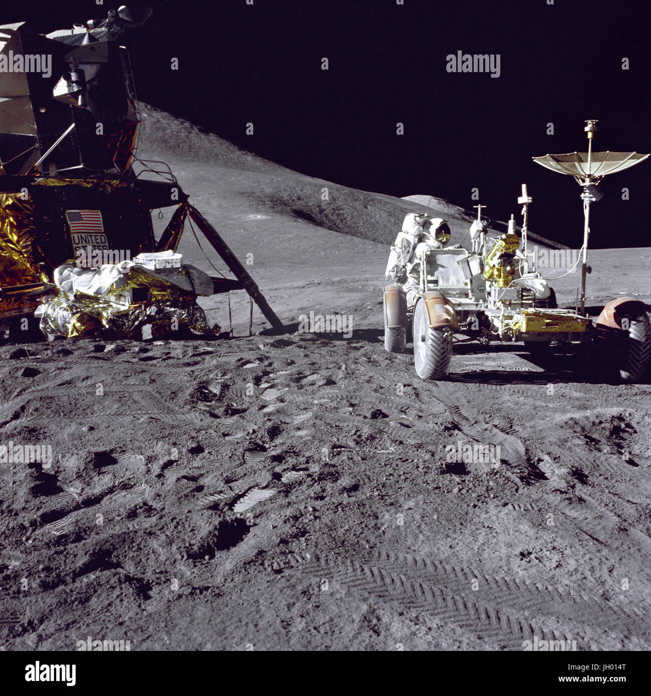 Irwin Lasten-Up der Rover. Pilot der Mondfähre Apollo 15 James B. Irwin Lasten-bis die "Rover", Lunar Roving Vehicle (LRV) mit Werkzeugen und Geräten in Vorbereitung für die erste lunar Extravehicular Tätigkeit (EVA-1) am Landeplatz Hadley-Apenninen. Ein Teil der Mondlandefähre (LM) "Falcon" ist auf der linken Seite. Die zurückgenommen bis Retro-Laserreflektor (LR-3) liegt oben auf der LM modulare Ausrüstung verstauen Montage (MESA). Diese Ansicht ist etwas westlich von Süden suchen. Hadley Delta und dem Apennin sind im Hintergrund auf der linken Seite. St. George Krater ist ca. 5 Kilometer (ca. 3 statu Stockfoto