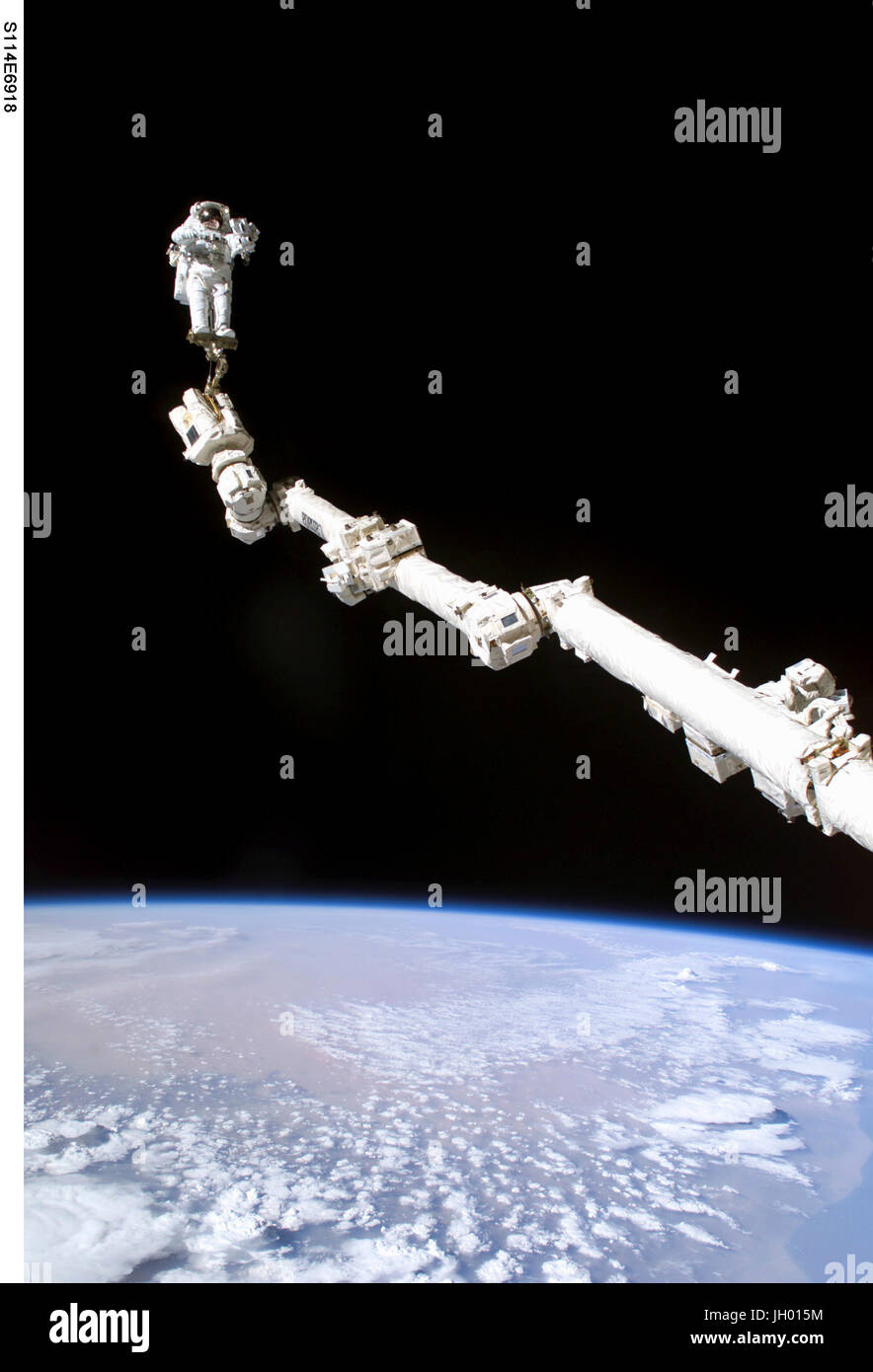 Astronaut Stephen K. Robinson, STS-114 Missionsspezialist verankert an einem Fuß Fessel auf der erweiterten internationalen Raumstation Canadarm2, beteiligt sich an der Mission dritten Tagung des Extravehicular Activity (EVA). Die Schwärze des Raumes und der Erde Horizont bilden die Kulisse für das Bild. NASA-Foto Stockfoto