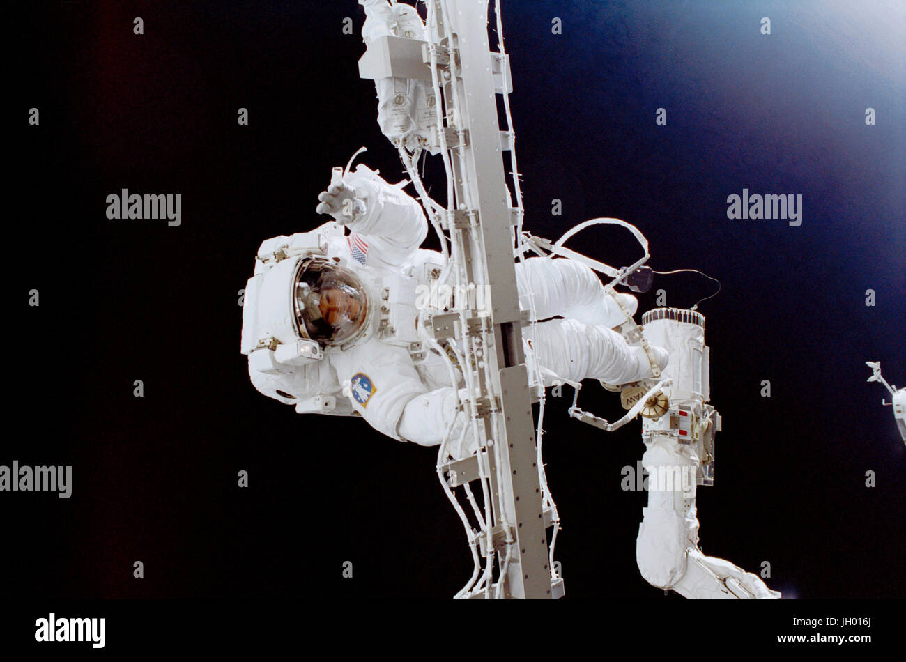 Astronaut Susan J. Helms arbeitet bei gedrückter auf eine starre Nabelschnur und mit ihren Füßen an das remote Manipulator System (RMS) Roboterarm auf das Space Shuttle Discovery verankert. Diese Extravehicular Activity (EVA), auf welche Helms gesellte sich Astronaut James S. Voss (aus Rahmen), war der erste von zwei geplanten STS-102 Weltraumspaziergänge. Das Paar, dazu bestimmt, die Expedition zwei Besatzungsmitglieder an Bord der Station später in der Mission, ritt an Bord der Discovery in den Orbit und zum Zeitpunkt dieser EVA galten noch als Spezialisten der STS-102-Mission. Stockfoto