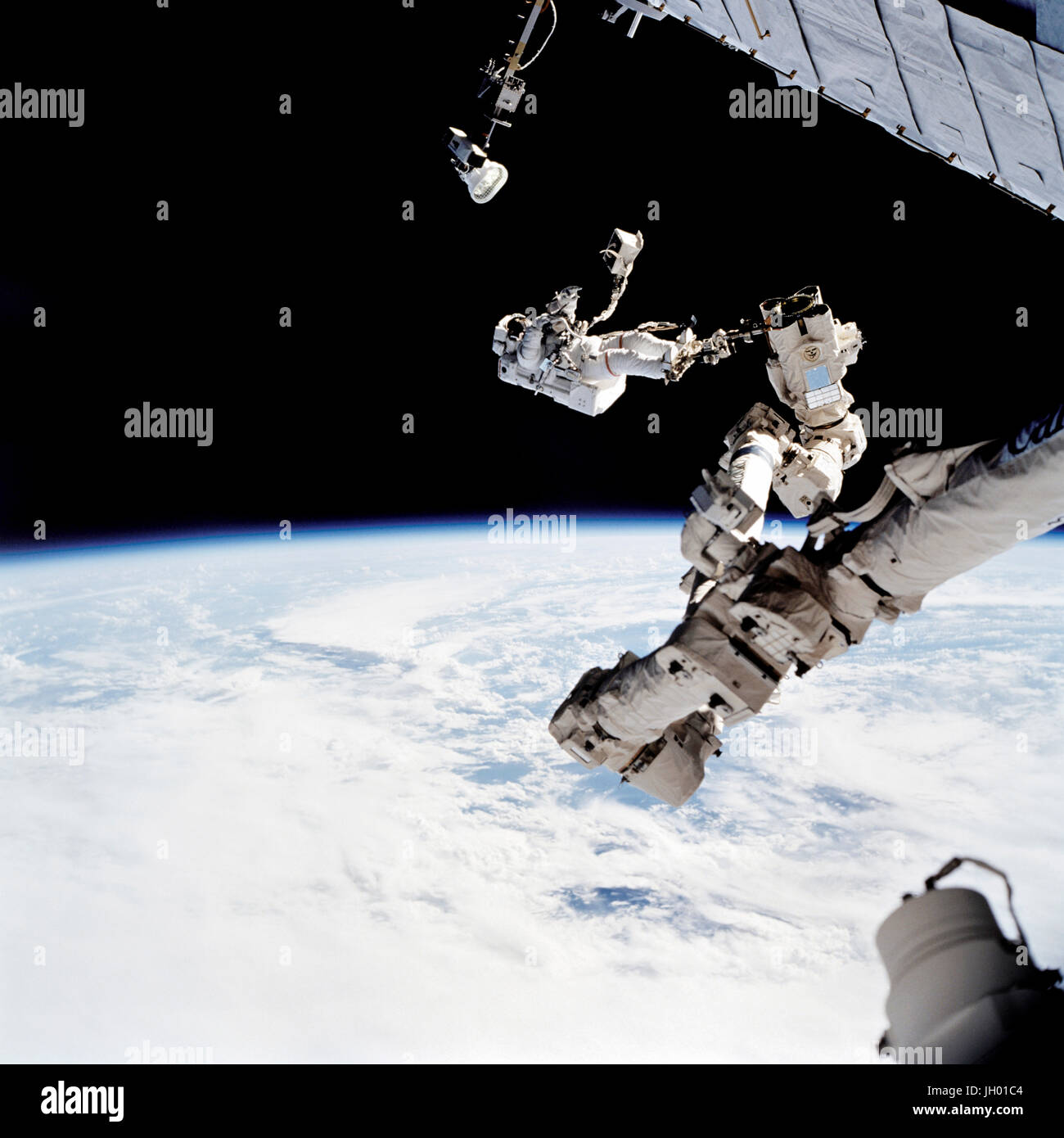 Astronaut David A. Wolf, STS-112 Missionsspezialist verankert an einem Fuß Fessel auf dem Space Station Remote Manipulator System (SSRMS) oder Canadarm2, trägt die Starboard One (S1) Außenborder Nadir externe Kamera. Die Kamera wurde während der Mission erste geplante Sitzung der Extravehicular Activity (EVA) am Ende der S1 Dachstuhl auf der internationalen Raumstation (ISS) installiert. NASA-Foto Stockfoto