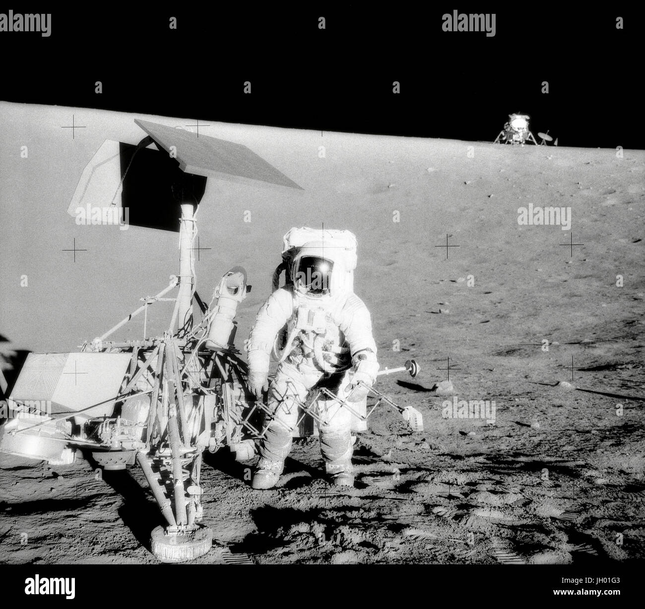 Conrad und Landvermesser am Hang eines Kraters. Charles Conrad Jr., Kommandant von Apollo 12, untersucht die unbemannte Raumsonde Surveyor III während der zweiten Extravehicular Activity (EVA-2). Die Mondlandefähre (LM) "Intrepid" im Hintergrund rechts ist. Dieses Bild wurde vom Astronaut Alan L. Bean, Lunar Module pilot aufgenommen. Die "Intrepid" landete auf des Mondes Ozean der Stürme nur 600 Fuß von Surveyor III. Die Fernsehkamera und mehrere andere Komponenten wurden Landvermesser III entnommen und brachte zurück auf die Erde für die wissenschaftliche Analyse. Landvermesser III auf dem Mond am 19. April 1967 zerstörte. Stockfoto